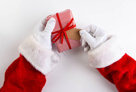圣诞老人手上拿着圣诞礼物的头部镜头被红条纹纸打成一面空图片