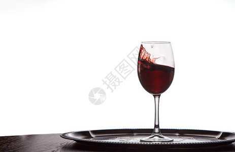 红酒从杯子上溢出留在木制图片