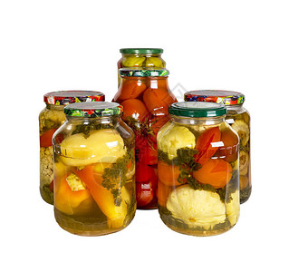 几罐装头蔬菜的玻璃罐子白背景孤图片