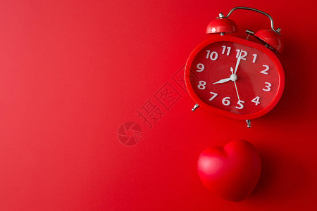 红背景和复制空间上的红闹钟和心脏形状背景图片