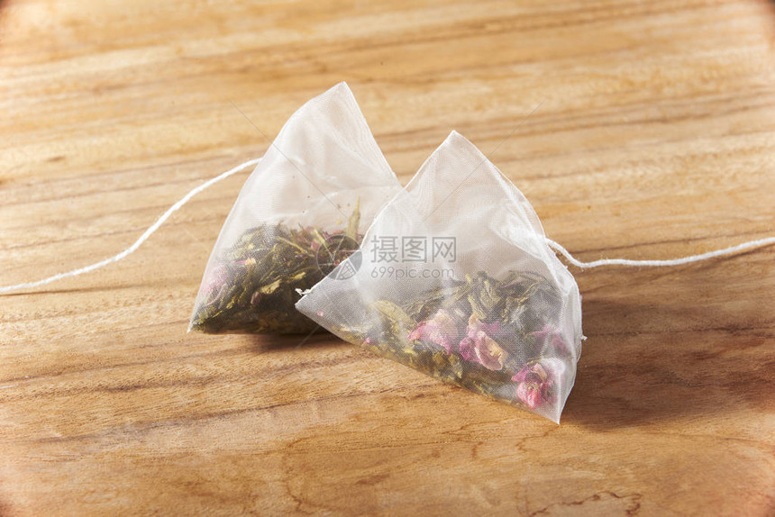 木板上两包蔓越莓绿茶包图片