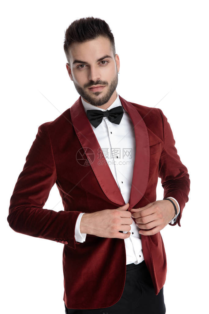 穿红色天鹅绒燕尾服的感青年男子修整大衣和在灰色背图片