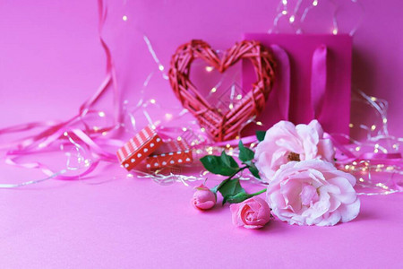 粉红色背景中的新鲜玫瑰红心照明情人节浪漫祝贺的概念生日快乐卡婚礼请图片