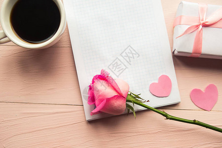 咖啡杯礼物盒和玫瑰花在粉红背景上图片