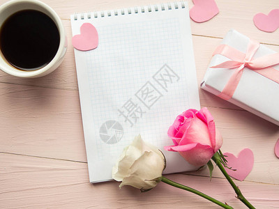 咖啡杯礼物盒和粉红背景的玫瑰图片