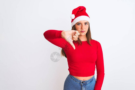 年轻漂亮的女孩戴着圣诞老人的帽子站在孤立的白色背景上图片