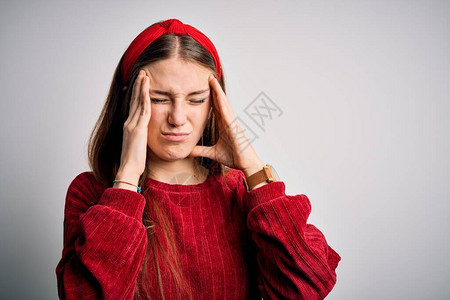 年轻漂亮的红发女人穿着红色休闲毛衣和黄色背景的王冠图片