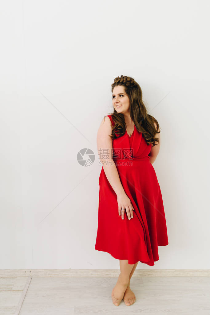 穿着时装红礼服站在白色背黑锅上一位美丽的caucasian图片