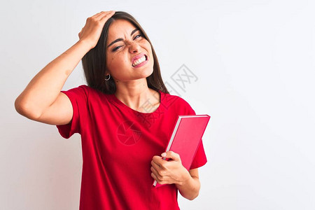 年轻漂亮的女学生拿着红书站在孤立的白色背景上图片
