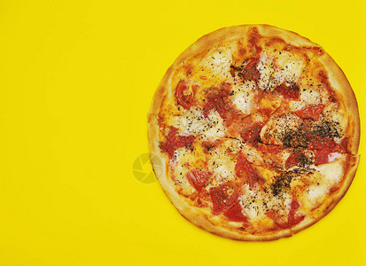 黄色背景上的美味比萨饼图片
