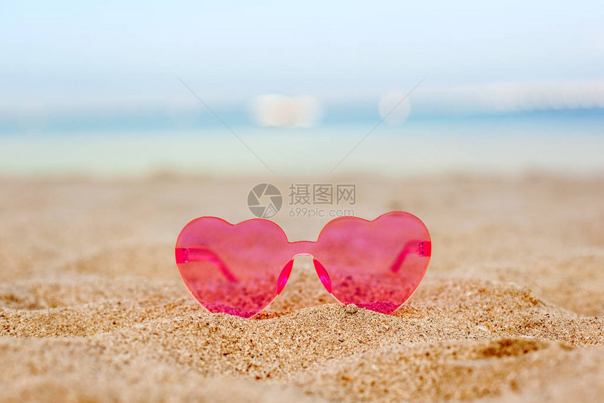 沙滩上的粉红太阳镜有蓝海背景蜜月度图片