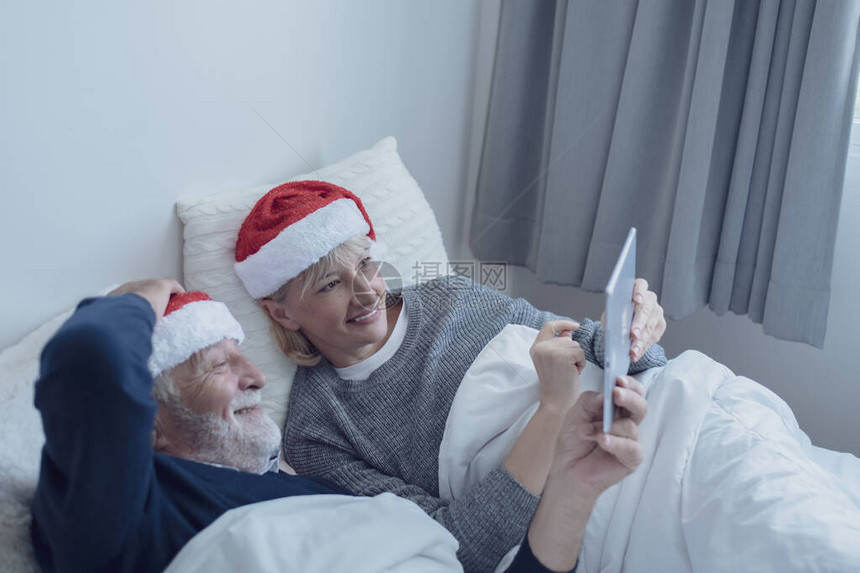 快乐的老年夫妇白种老人和女人戴着红帽说话的家庭图片