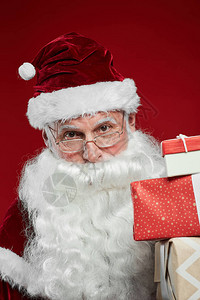 圣诞老人戴帽子的肖像拿着礼盒看着红图片