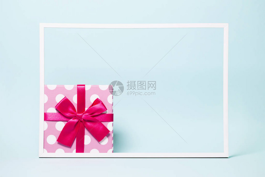 用明亮的丝带在彩色背景上用白色框架包裹着圆点的礼物盒节日和节日主题圣诞节或生日礼物销售图片