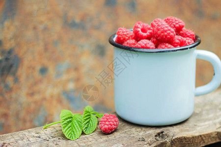蓝色的金属古董杯子满是草莓浆果多汁美味健康的点心丰图片