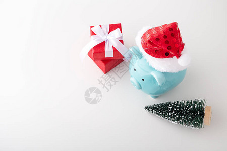 穿戴圣诞帽带红礼盒的猪头银行和白底染着圣诞图片