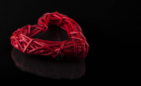 深色背景上藤蔓的红色编织心图片