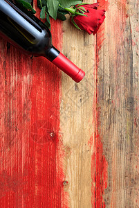 红酒瓶和火情红色玫瑰花在木材背景