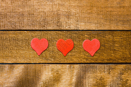 木制背景上的三颗红心图片