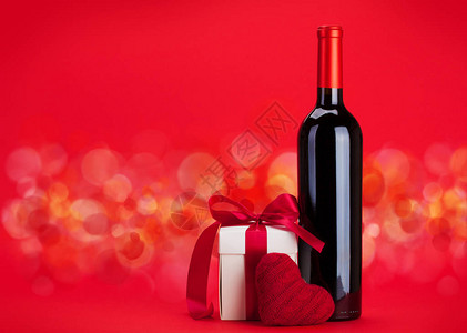 情人节礼物盒和红酒瓶在红色背景上图片
