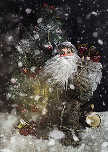 圣诞老人在降雪的圣诞树旁为孩子们携带礼物圣诞快图片