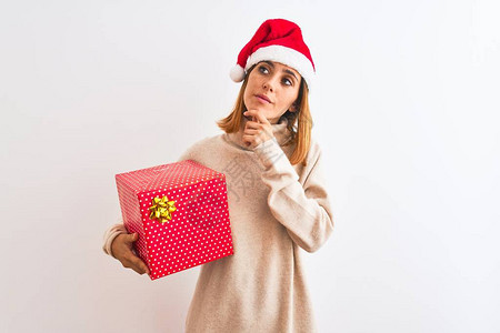 戴着圣诞帽的漂亮红发女人拿着礼物图片