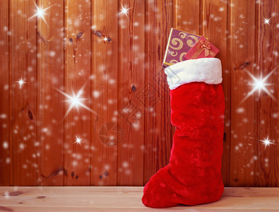 圣诞短袜站在木墙附近带背景图片