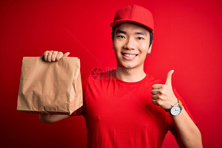 年轻英俊的送货员拿着外卖纸袋图片