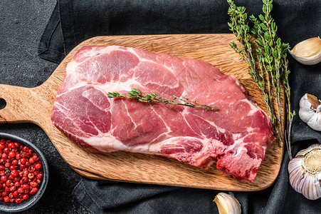 生猪肉牛排准备配菜和香料的生肉片黑色背图片