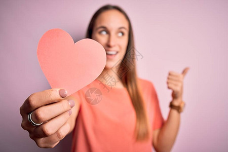 年轻美丽的浪漫女人拿着纸心形图片