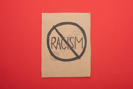 红色背景上禁止种族主义标志的纸图片