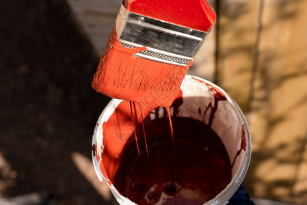 红褐色油漆从刷子流到桶里油漆表图片