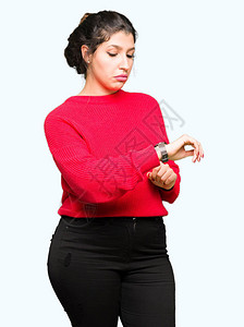 年轻美女穿着红色毛衣和包的红毛衣检查手表时间图片