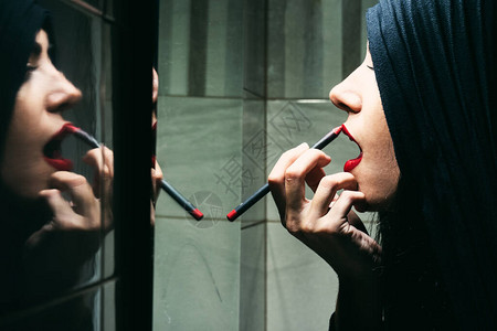 在镜子前化妆的阿拉伯女人图片
