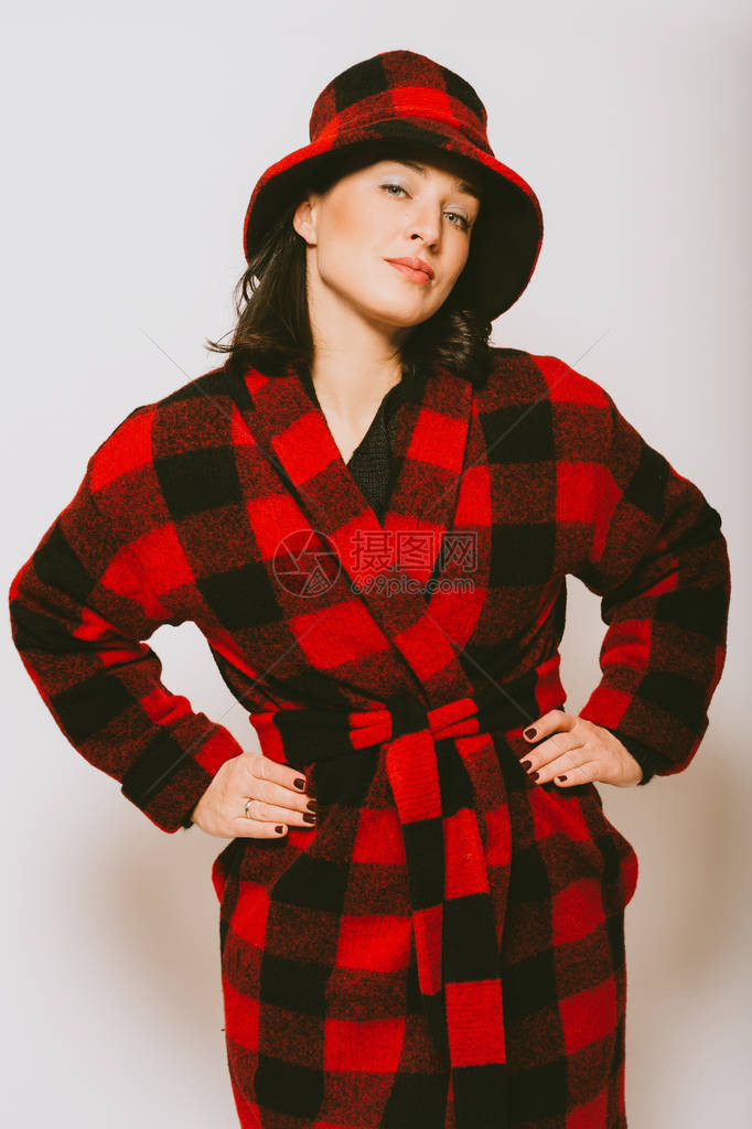 穿着格子红黑外套和帽子的漂亮女人的工作室肖像图片