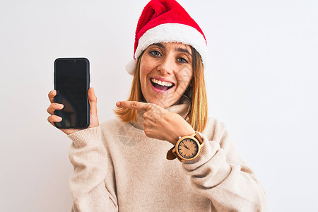 穿着圣诞帽的漂亮红发美女戴上智能手机屏幕以手和指图片