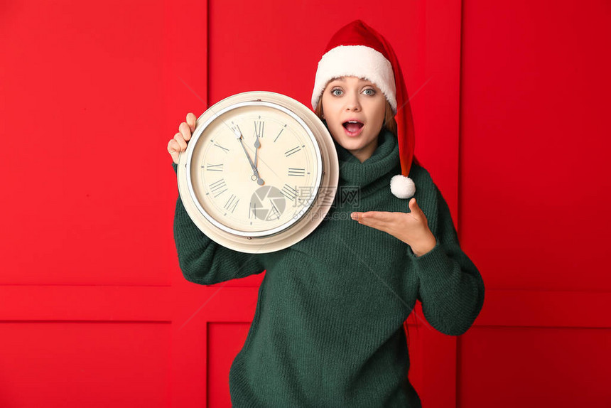 圣诞倒计时概念圣塔帽和有色的钟表的图片