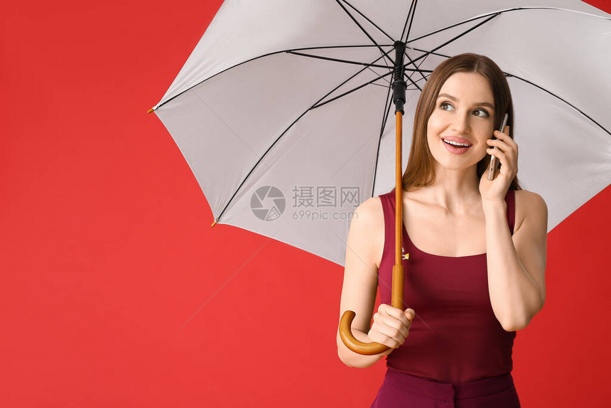 配有雨伞的漂亮女人用手机聊天图片