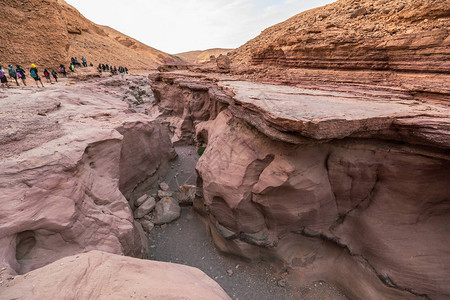 以色列红峡谷Bizarre岩层上旅行的一群图片