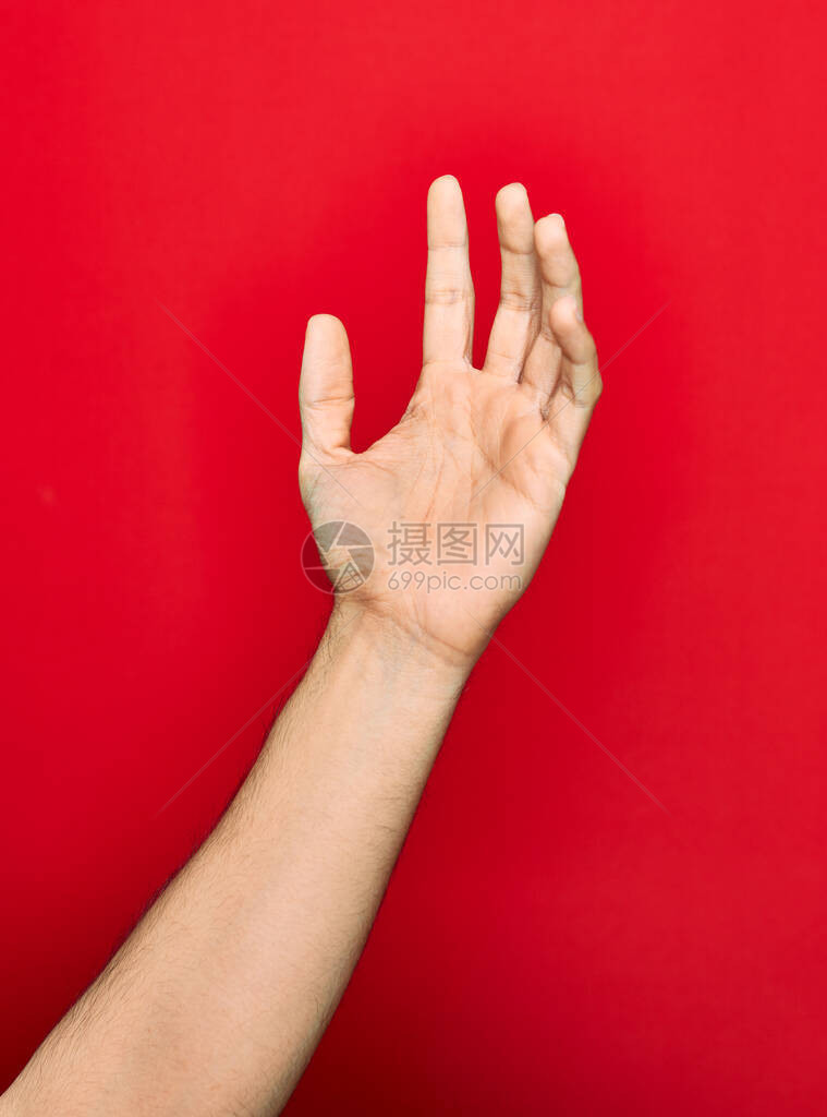 美丽的男人的手五指高举五指在孤立的红图片