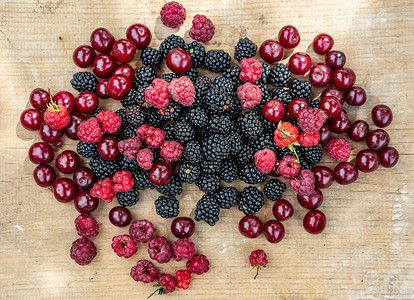 黑熟的野莓黑红樱桃和草莓图片