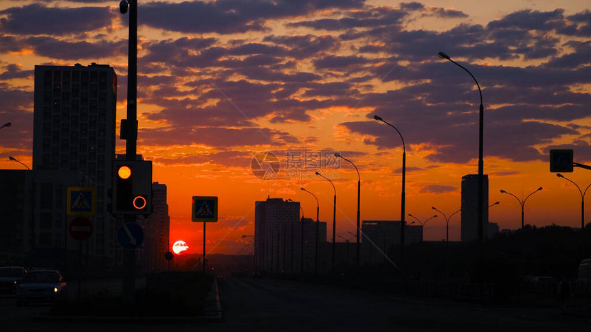 城市景观与红色夕阳天空背景下的高速公路概念城市房屋的深色剪影背景在日落地平线图片