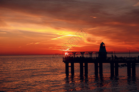 灯塔码头和水面上的落日图片