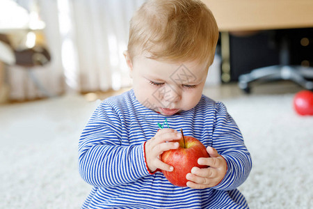 小可爱的女婴吃大红苹果适合小孩子的维生素和健康食品6个月的漂图片