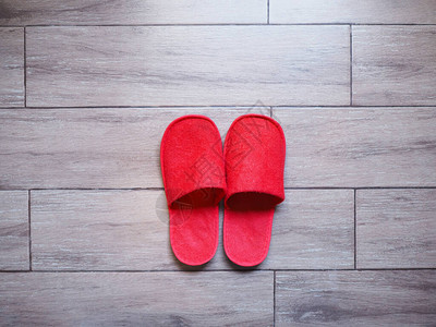 红色家庭布料可一次拖鞋在木地板的瓷砖图片