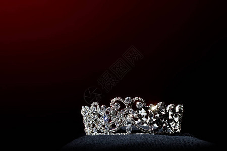 环球小姐选美世界大赛银钻冠在黑色枕头上闪发光背景图片