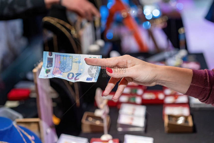 支付现金在当地市场用20欧元钞票支付妇图片