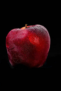 黑色背景中突显的鲜美红苹果苹果上有水滴图片