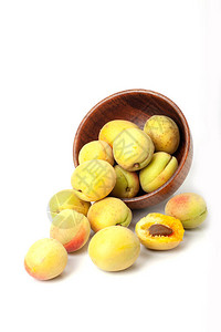 木碗里新鲜的成熟杏子在白色图片