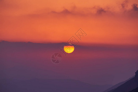 景观与美妙的金色夕阳在日落与大黄色太阳盘山森林覆图片